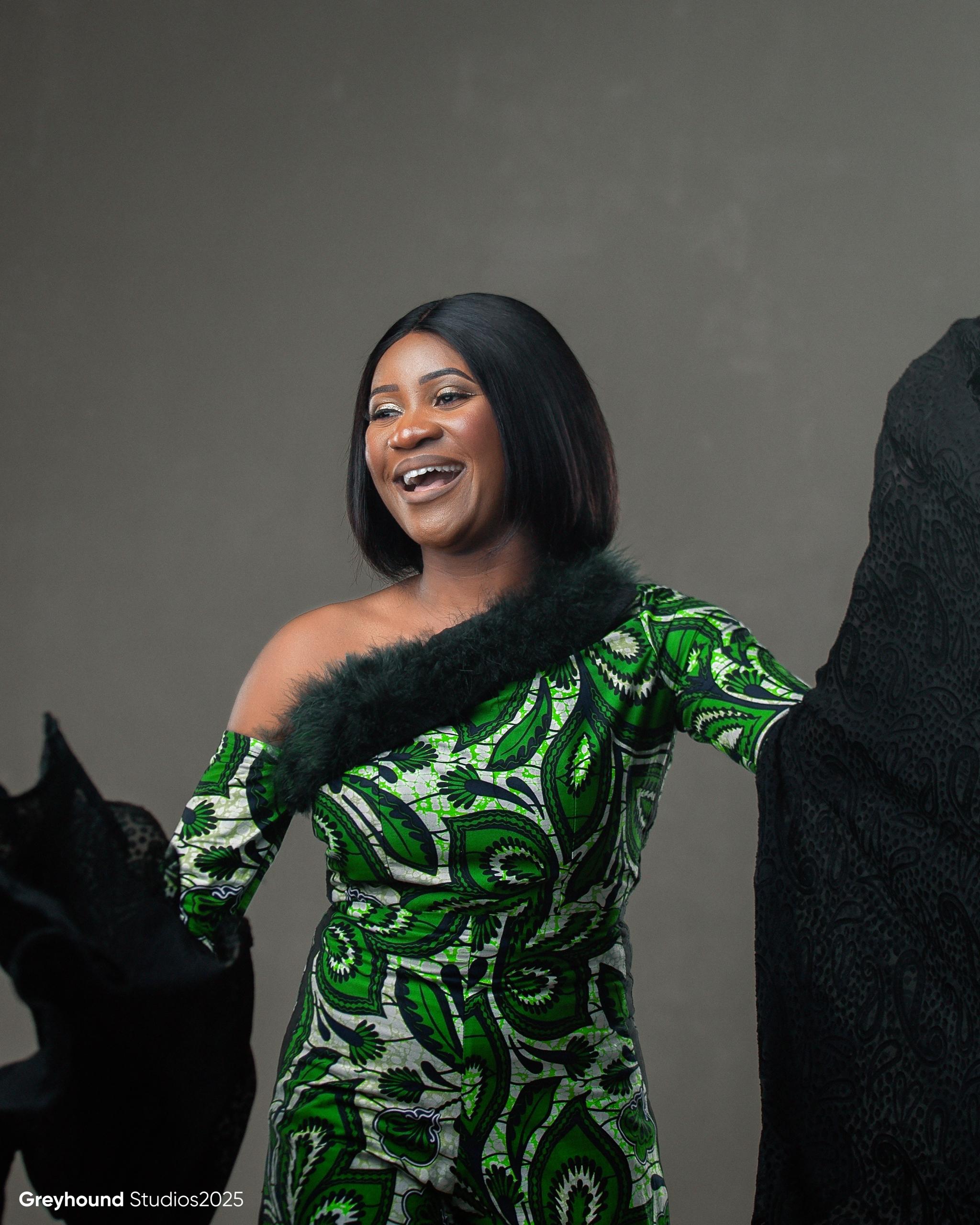 Tendai Makoni laughing joyfully in green African print dress with fur trim